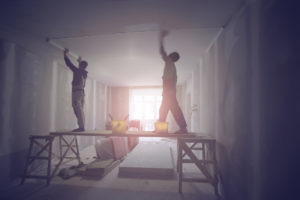 two people repairing ceiling